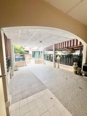 Spacious front patio with tiled flooring and covered parking area