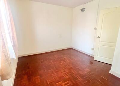 Empty bedroom with parquet flooring and white walls