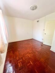 Empty bedroom with parquet flooring and white walls