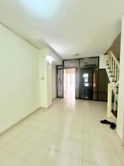 Bright and spacious hallway with tiled flooring and staircase