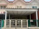 Front view of a two-story residential building with gated entrance