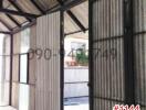 Unfinished interior of a building with exposed structure and corrugated metal walls