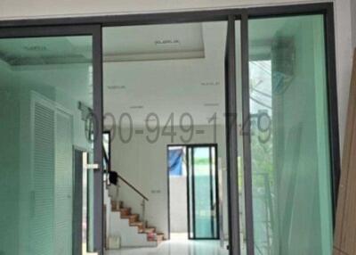 View of a home entrance with sliding glass doors and stairs in the background