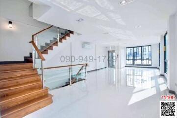 Spacious and bright interior with staircase and glossy floor finish