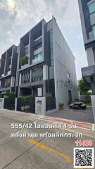 Modern multi-story residential building with a balcony and plant decorations