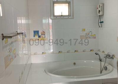 Bright and clean bathroom with bathtub and tiled walls