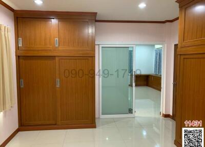 Spacious bedroom with wooden wardrobes and glossy tiled flooring