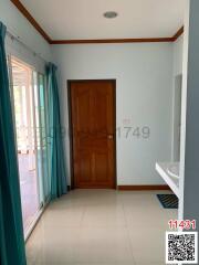 Bright bedroom with a wooden door leading to a balcony and a hint of an en-suite bathroom