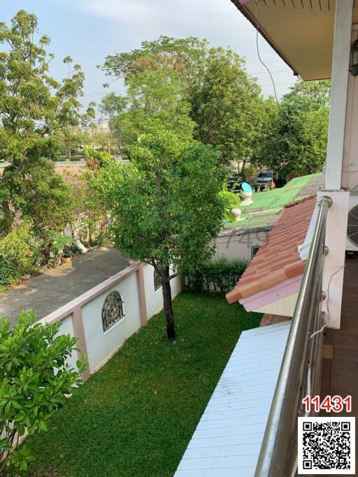 Spacious balcony overlooking green backyard with trees