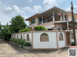 Two-story residential home with balcony and gated perimeter