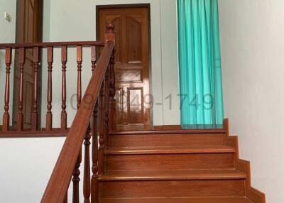 Wooden staircase with handrails leading to the upper level of a house
