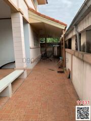 Paved outdoor patio area with a covered section and storage space