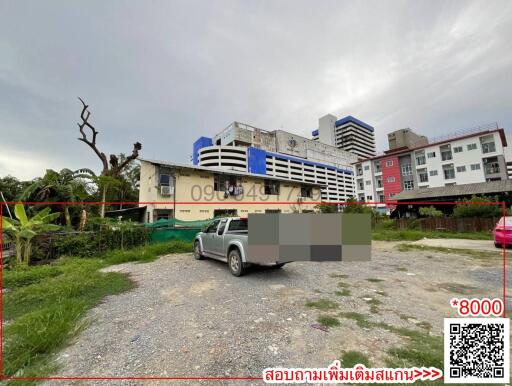 Exterior view of urban building with parking and greenery