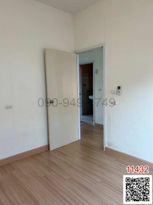 Empty bedroom with wooden flooring and white door