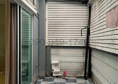 Covered balcony area with tiled flooring and metal shutters