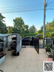 Paved patio area with vehicle parking and potted plants under a shelter