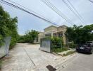 Exterior view of a residential building with gated entrance and parked car