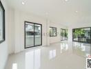 Spacious and bright living room with large windows and glossy tiled floor
