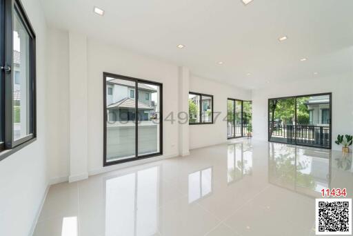 Spacious and bright living room with large windows and glossy tiled floor