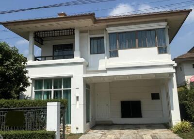 White two-story house with a balcony and garage