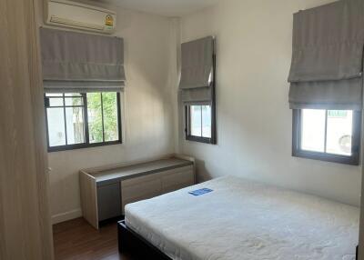 Bright and airy bedroom with a large bed, window dressings, and air conditioning
