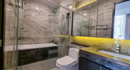 Modern bathroom with glass shower enclosure and marble finishes