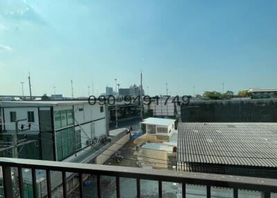 View from balcony overlooking industrial area with clear blue sky