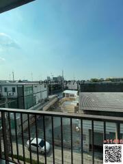 View from balcony overlooking industrial area with clear blue sky