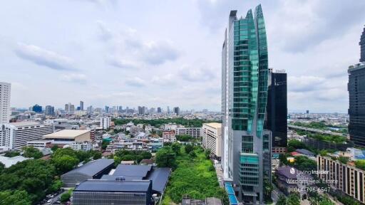 Aerial view of a cityscape showcasing skyscrapers and urban development under a cloudy sky