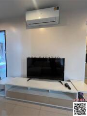 Modern living room with large television and air conditioning unit