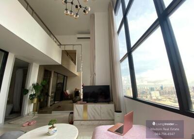 Spacious living room with high ceilings and city view