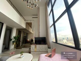 Spacious living room with high ceilings and city view