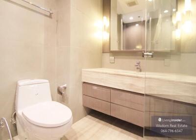 Modern bathroom with wooden vanity and well-lit mirror