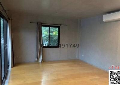 Spacious unfurnished living room with large window and hardwood flooring