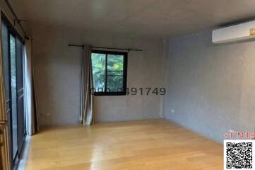 Spacious unfurnished living room with large window and hardwood flooring