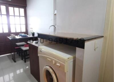 Compact kitchen area with modern appliances and dining table in the background