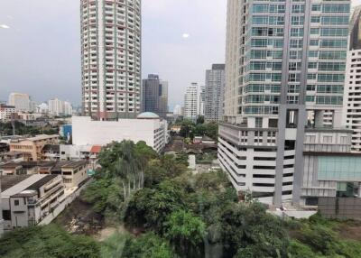 Cityscape view from a high-rise building showing nearby structures and vegetation