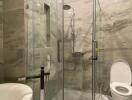 Modern bathroom with glass shower enclosure and marble walls