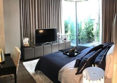 Elegant bedroom with a modern aesthetic, featuring a large window and sophisticated decor