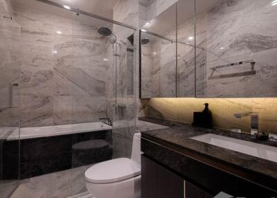 Modern bathroom interior with marble tiles, glass shower, and bathtub