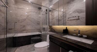 Modern bathroom interior with marble tiles, glass shower, and bathtub