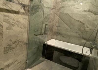 Modern bathroom with glass shower and marble walls