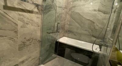 Modern bathroom with glass shower and marble walls