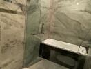 Modern bathroom with glass shower and marble walls