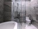 Modern bathroom with marble design, glass shower, and free-standing bathtub