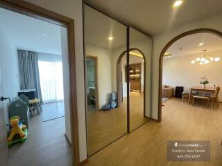 Spacious living room with large mirror and dining area