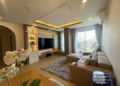 Modern and cozy living room with ample lighting and comfortable furnishings