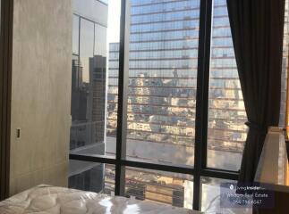 Modern bedroom with large window overlooking the cityscape