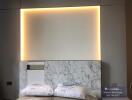 Modern bedroom with ambient lighting and marble headboard