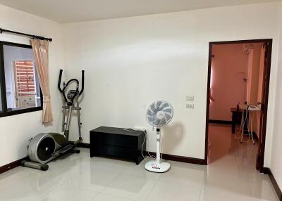 Spacious bedroom with exercise equipment and large window